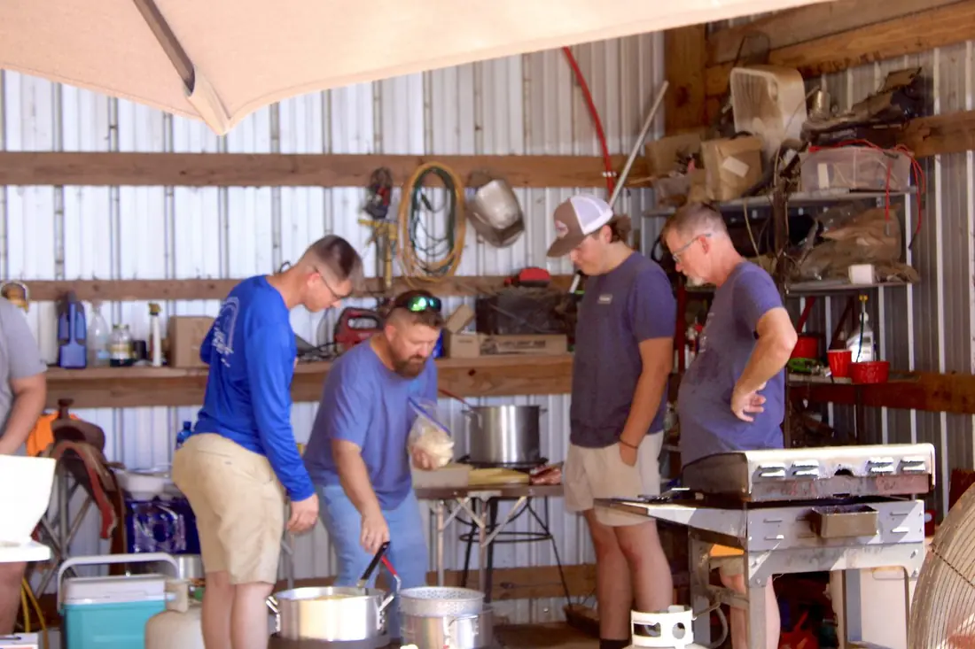 Men frying fish and hushpuppies at the cook station